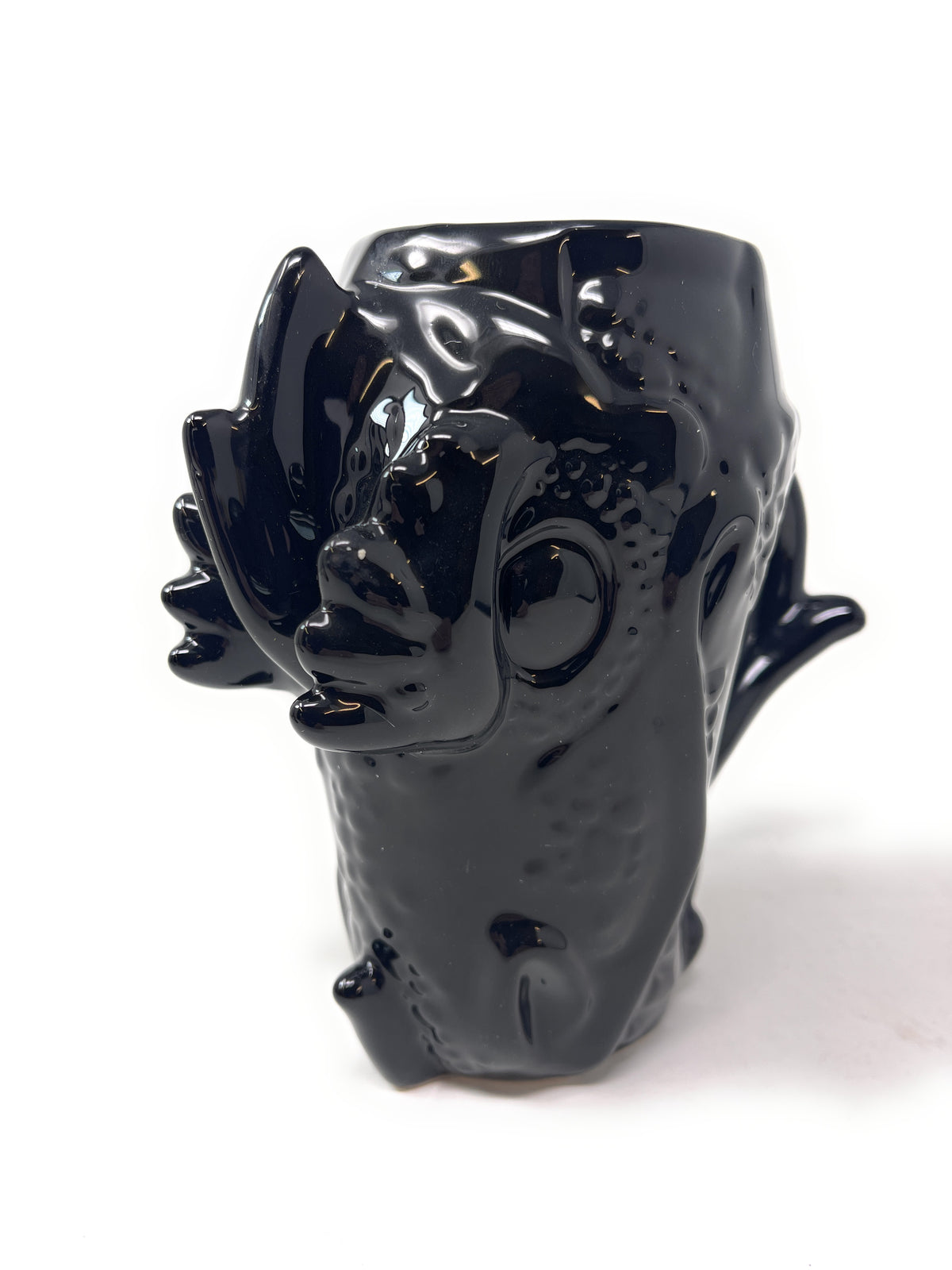 A glossy black ceramic mug shaped like a stylized dragon head, shown on a plain white background.