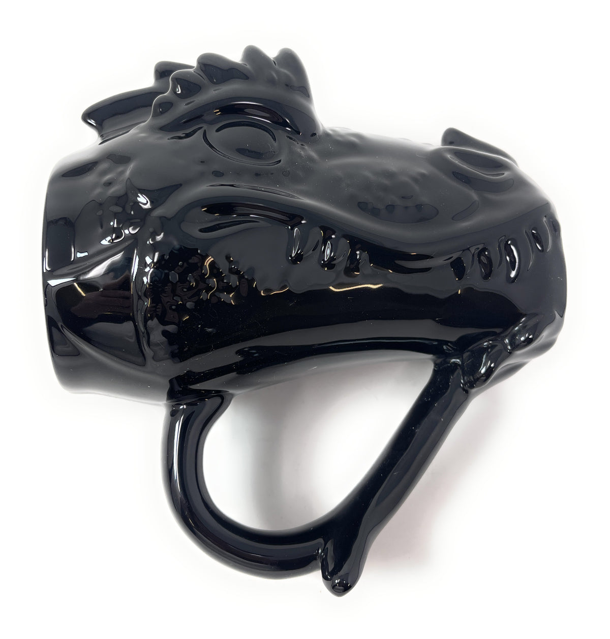 A glossy black ceramic mug shaped like a dinosaur head, shown from a side profile view against a plain white background.