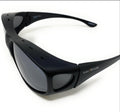 Black wrap-around sunglasses with dark lenses and 'SolarShield+' branding on the temple, photographed on a clean white background.