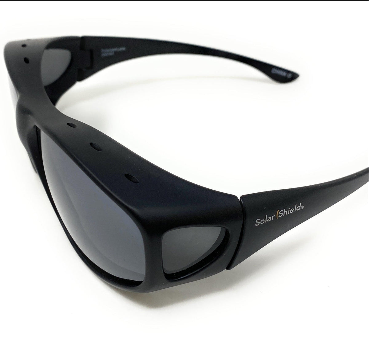 Black wrap-around sunglasses with dark lenses and 'SolarShield+' branding on the temple, photographed on a clean white background.